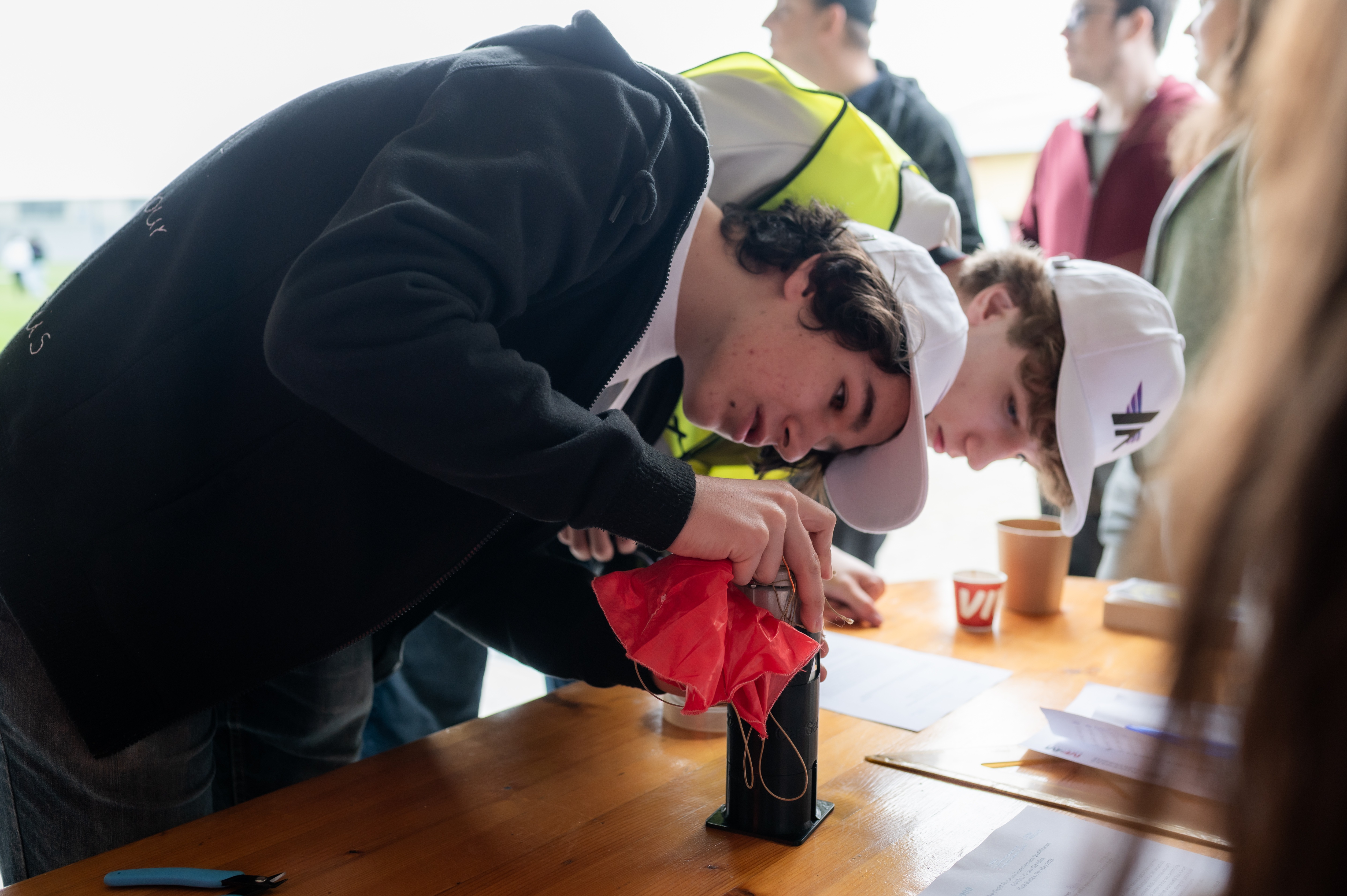 Team working on CanSat parachute system during competition